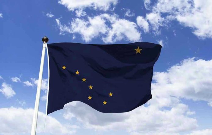 1363238492 Alaska state flag flying against a blue sky