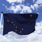 Alaska state flag flying against a blue sky