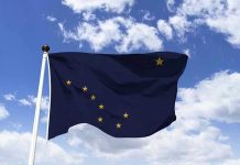 Alaska state flag flying against a blue sky