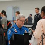 TSA agent checks passengers documents at airport security