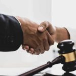 Handshaking near a gavel on desk