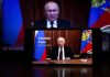 Man speaking on screen with Russian flag background