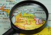 Russian Missiles Stalk US Warships—Caribbean On Edge Magnifying glass focusing on Venezuela and Colombia on map
