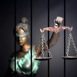 Legal Bombshell: Turley Slams Prosecutor’s Overreach Blindfolded Lady Justice statue holding scales behind bars
