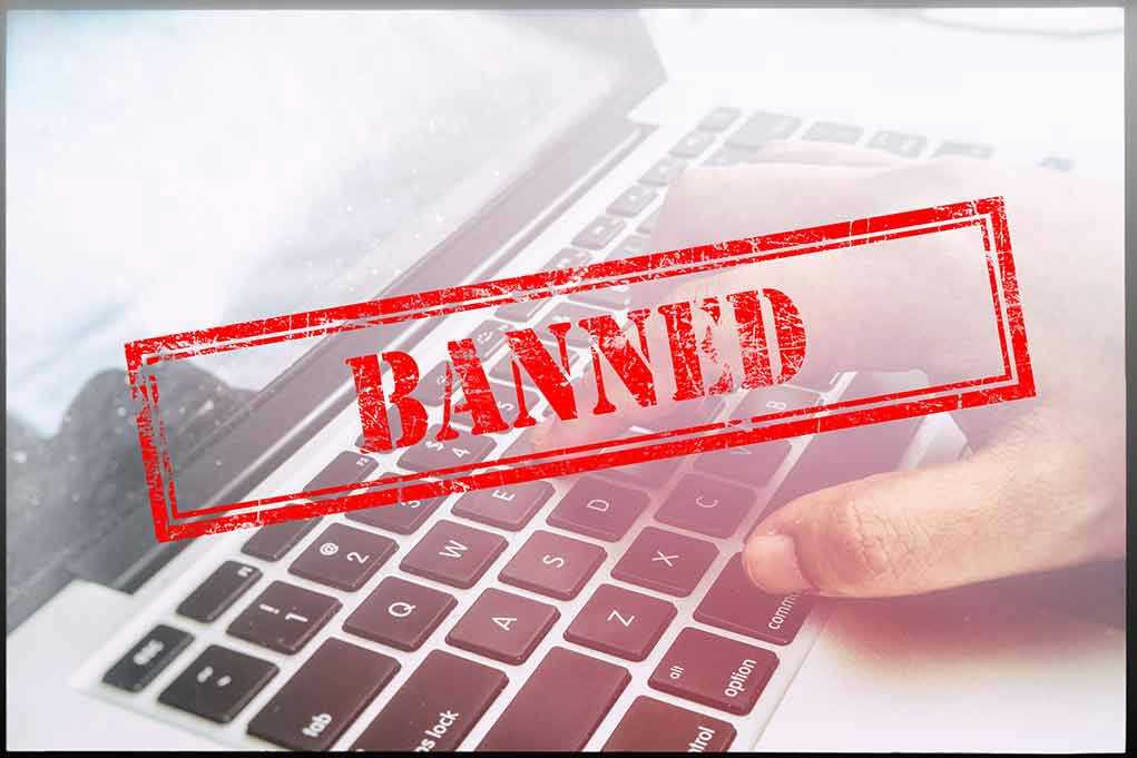 Red Banned stamp over a laptop keyboard