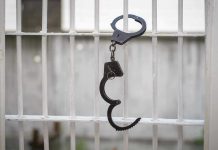 MS-13 Kingpin Roamed Free — State APPALLED Handcuffs hanging on white metal bars