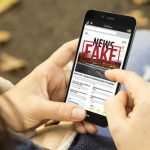 Person reading FAKE NEWS on smartphone