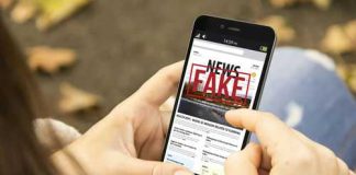 Person reading FAKE NEWS on smartphone
