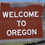 Welcome sign to Oregon with a brown background and white text