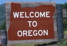 Welcome sign to Oregon with a brown background and white text