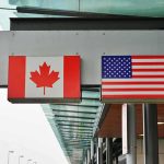Canadian and American flags displayed at a border crossing