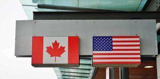 Canadian and American flags displayed at a border crossing