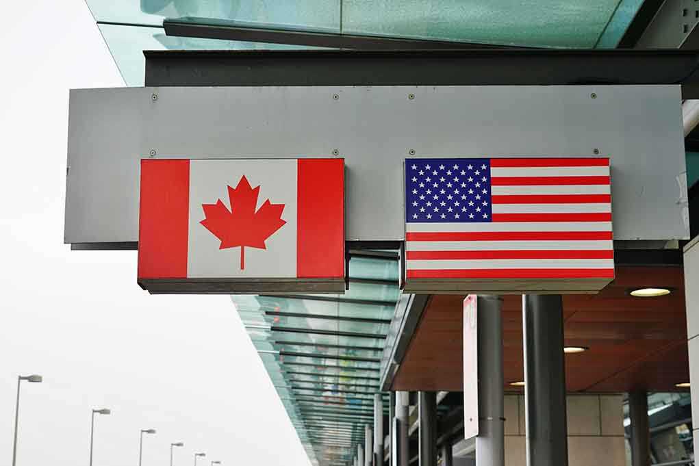 Canadian and American flags displayed at a border crossing