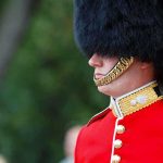Andrew’s Royal Standoff: Monarchy Tied in Legal Knots British soldier in ceremonial uniform with a black fur hat standing guard