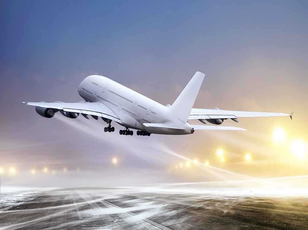 An airplane taking off from an airport runway against a twilight sky