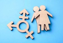 Trump’s Bold Deportation Move Defies Courts Wooden transgender symbol and couple figures on blue background.