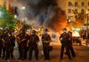 Political Violence EXPLOSION: America On Edge Police officers in riot gear near burning car