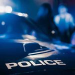 Manhunt: How Did Slender Man Attacker Escape? Police car with blurred figures in the background.