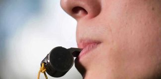 Person holding a whistle in their mouth.