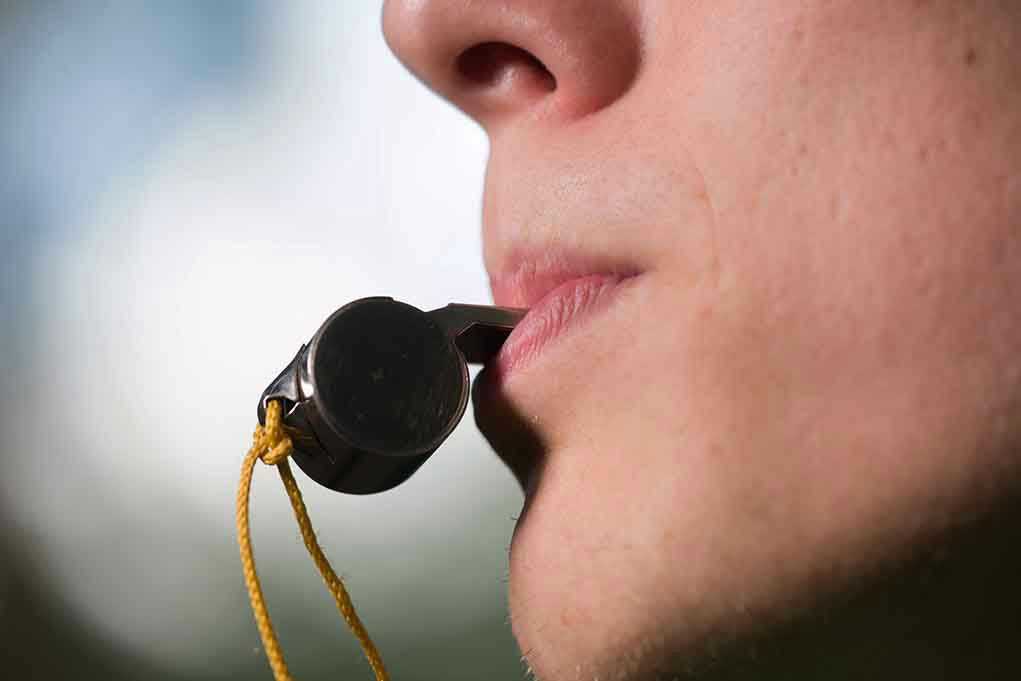 Person holding a whistle in their mouth.