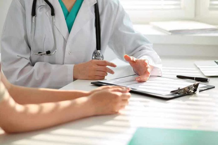 Doctor discussing with patient holding clipboard on desk