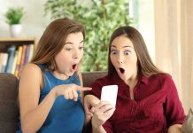 Two women look surprised at a phone