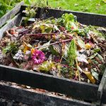 A compost pile filled with various organic materials and flowers