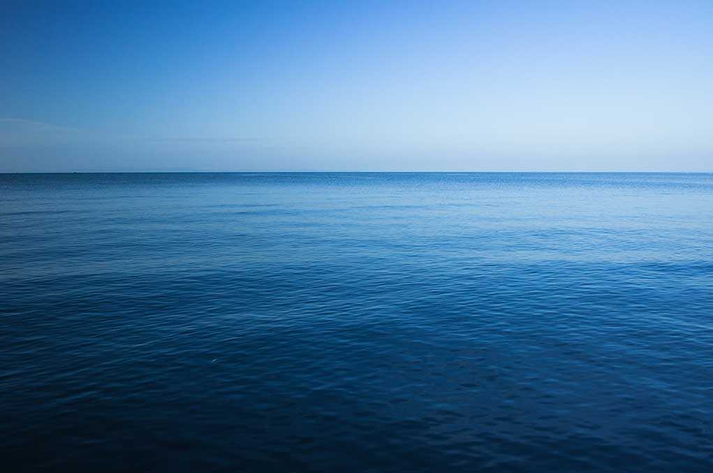 A calm ocean under a clear blue sky