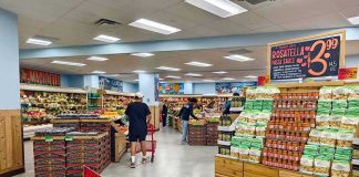 Interior of a grocery store with customers shopping for fresh produce