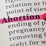 Abortion highlighted in a dictionary with a pink marker.
