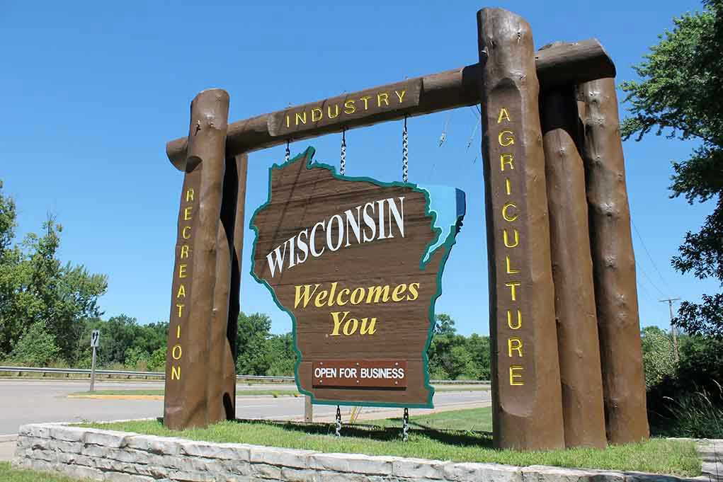 Wisconsin welcome sign with industry, agriculture, and recreation.