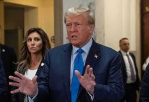 Congress Moves Against Trump–National Security at Stake Man speaking with hands raised, woman and security behind.