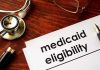 Stethoscope pen document about Medicaid eligibility on table