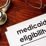 Stethoscope pen document about Medicaid eligibility on table