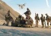Shocking! Robots to Lead in Battle Over Humans Soldiers operating a drone in a desert environment.
