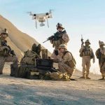 Soldiers operating a drone in a desert environment.