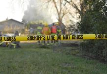 Mother MURDERS Toddler — Then Asks Strangers For Money Yellow police tape marking a restricted area at a fire scene with firefighters in the background
