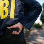 FED Buildings Breached — Trump Flips Switch FBI agent holding a gun behind the back.