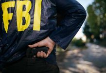 FED Buildings Breached — Trump Flips Switch FBI agent holding a gun behind the back.