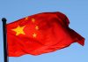 Communist Takeover Plot EXPOSED! Chinese flag waving against a clear blue sky