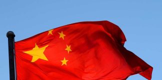 Chinese flag waving against a clear blue sky