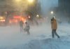 People walking in a snowy urban street during a blizzard