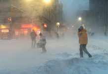 People walking in a snowy urban street during a blizzard