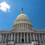 U.S. Capitol building against a clear blue sky.