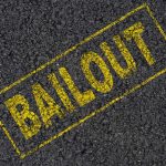 Yellow BAILOUT text marked on a black asphalt surface