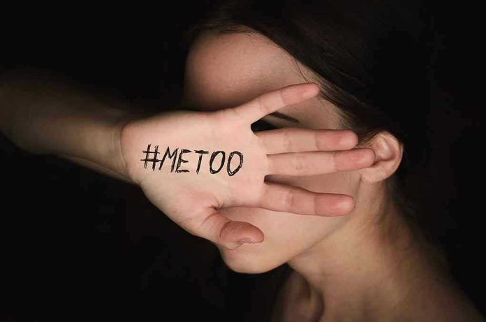 Hand with #MeToo covering face.