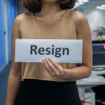 TikTok Hate Erupts — Credit Union Scrambles Person holding a sign that says resign