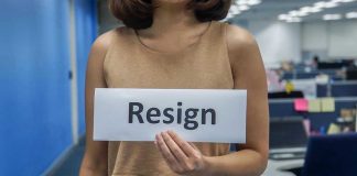 TikTok Hate Erupts — Credit Union Scrambles Person holding a sign that says resign