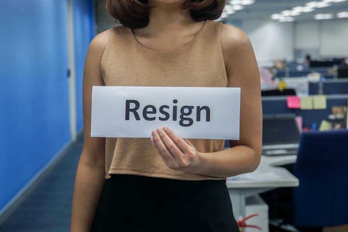 1142515304 Person holding a sign that says resign