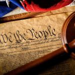 Naturalized Congress Members Face Ominous Ban Gavel on U.S. Constitution with flag backdrop.